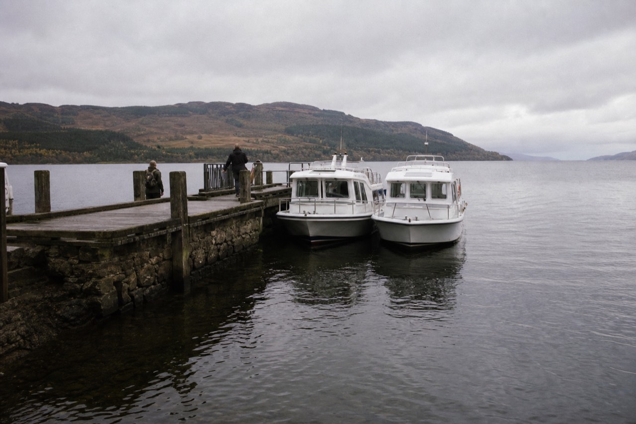 Cruise boats moored at Clansman Harbour pier on the shore of Loch Ness near Inverness